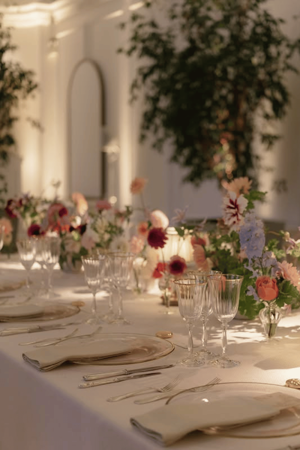 Moody candlelit table with soft florals and neutral-toned place settings