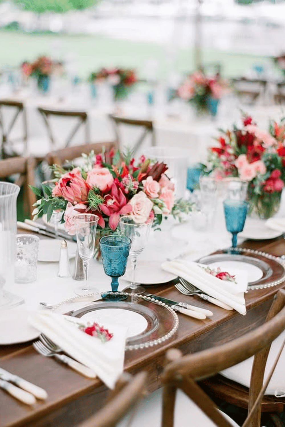 Bold wedding table with berry-toned florals and dusty blue accents
