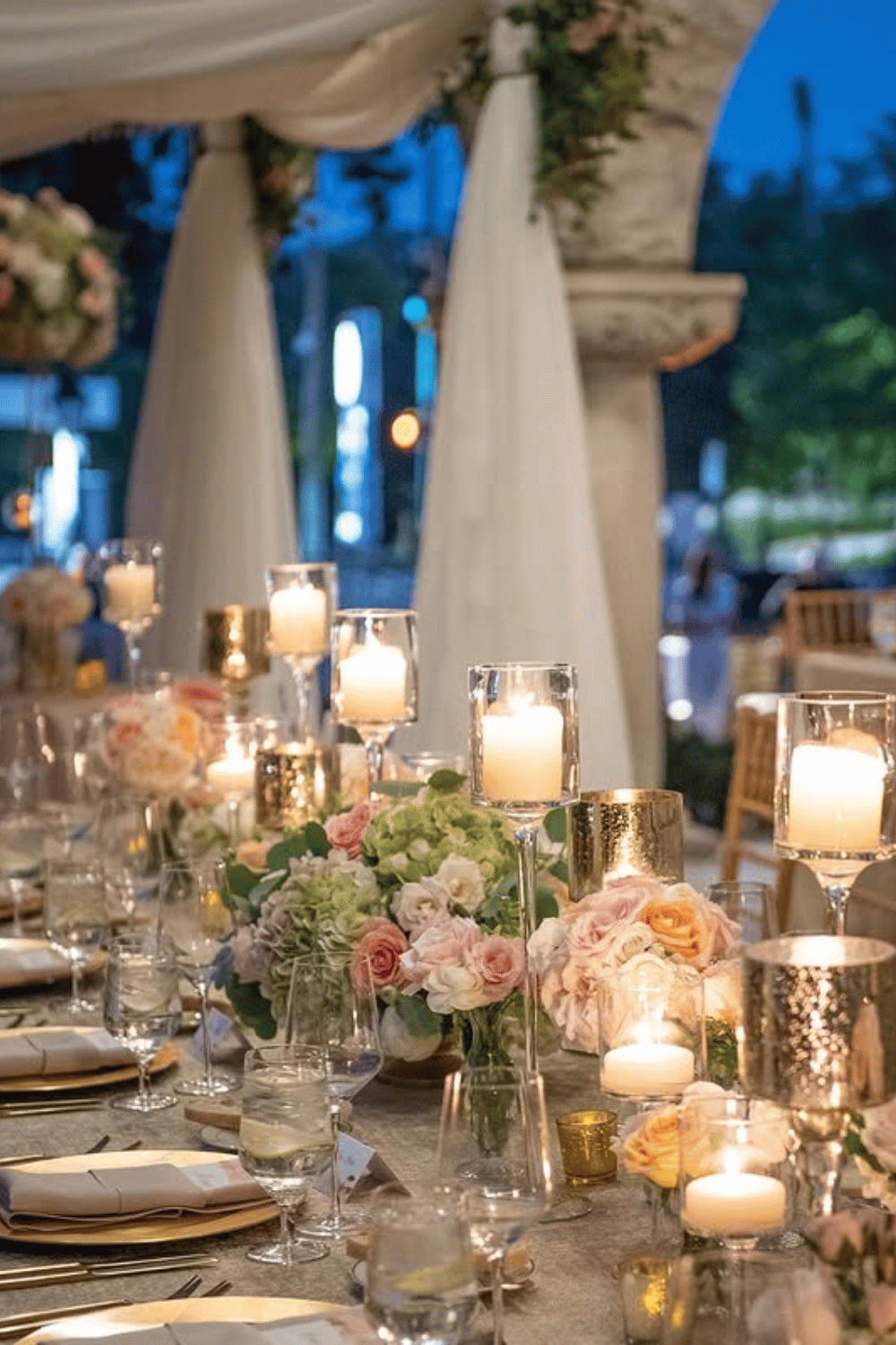 Elegant table with gold candle holders, soft blooms, and modern linens