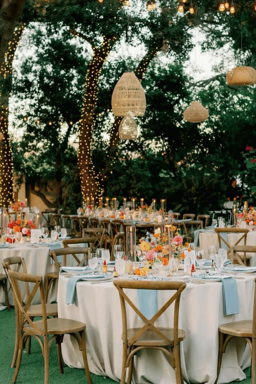 Outdoor wedding reception with string lights and pastel garden florals