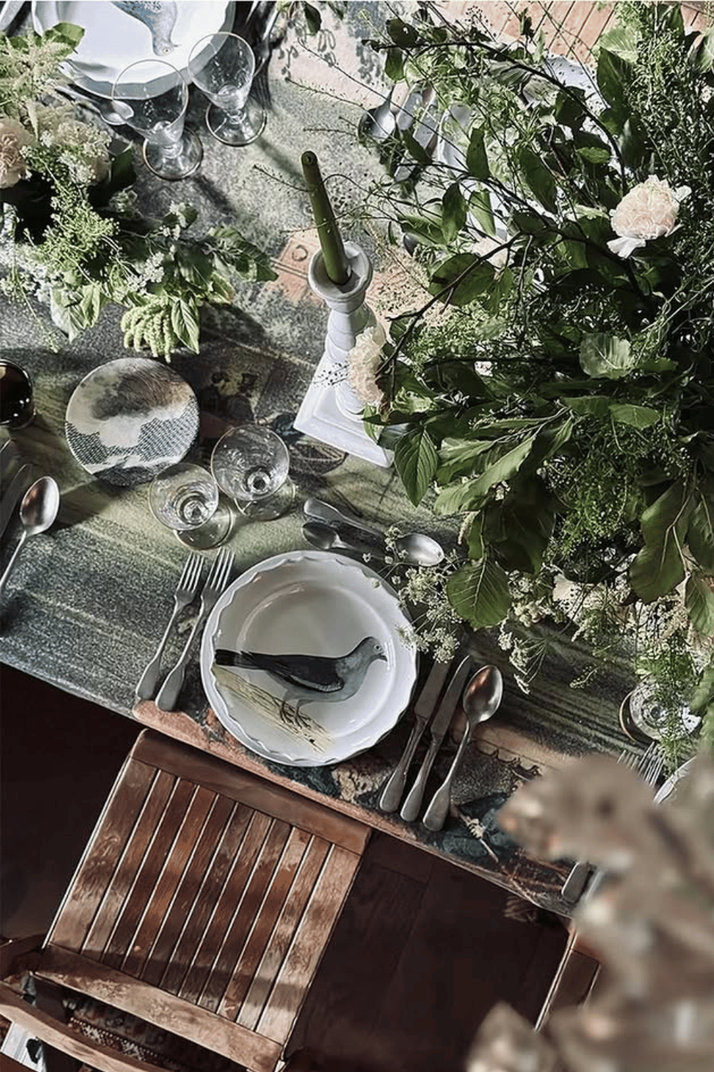 Whimsical bird-themed place setting with green foliage and unique salad plate