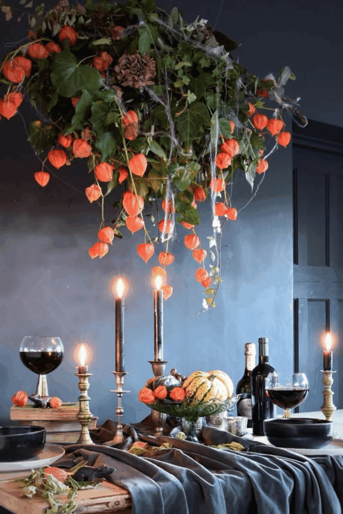 Moody Halloween table with hanging orange lanterns and black candles