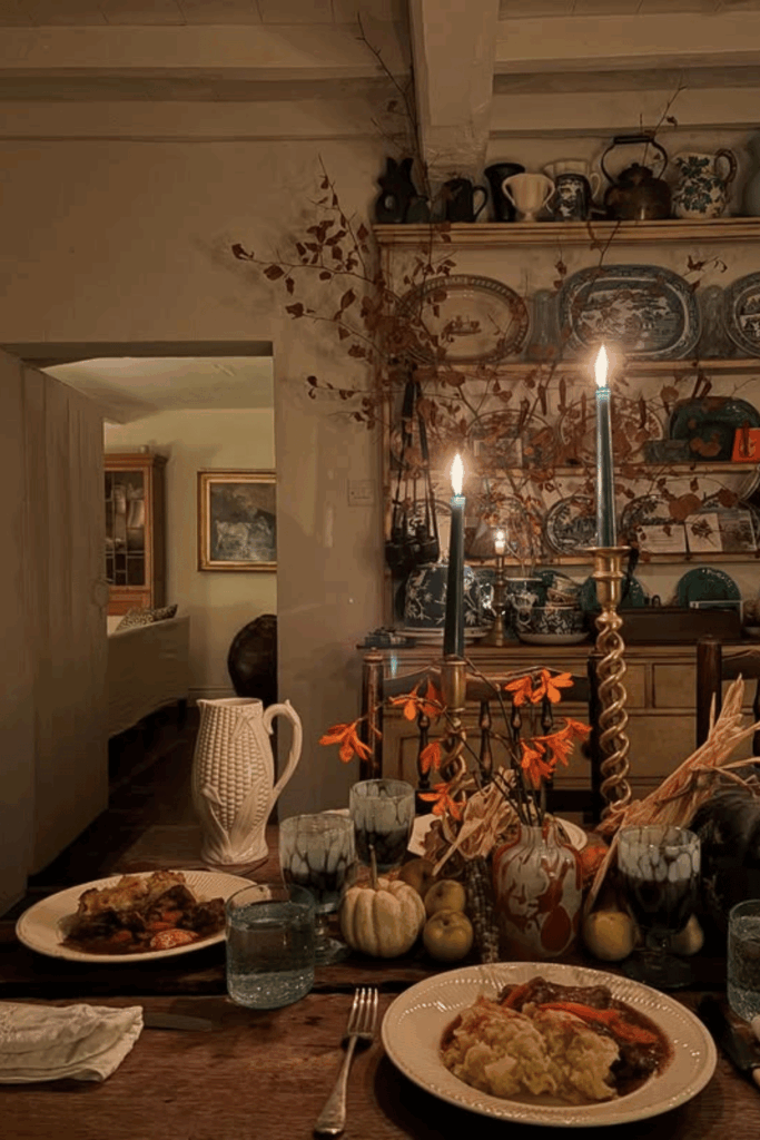 Rustic fall dining table with candles, pumpkins, and natural greenery