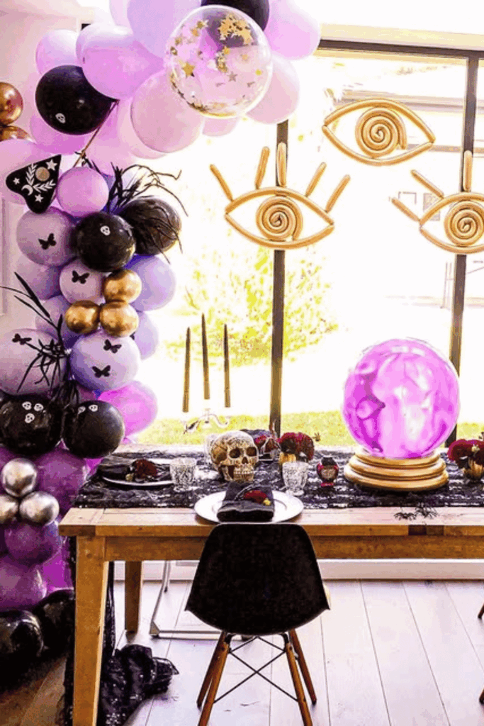 Halloween table with balloon arch and crystal ball centerpiece
