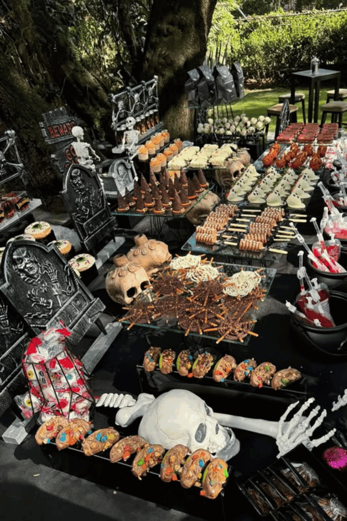 Outdoor Halloween dessert table with candy and skull props