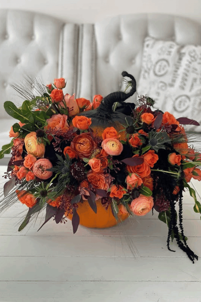 Pumpkin centerpiece filled with colorful fall flowers
