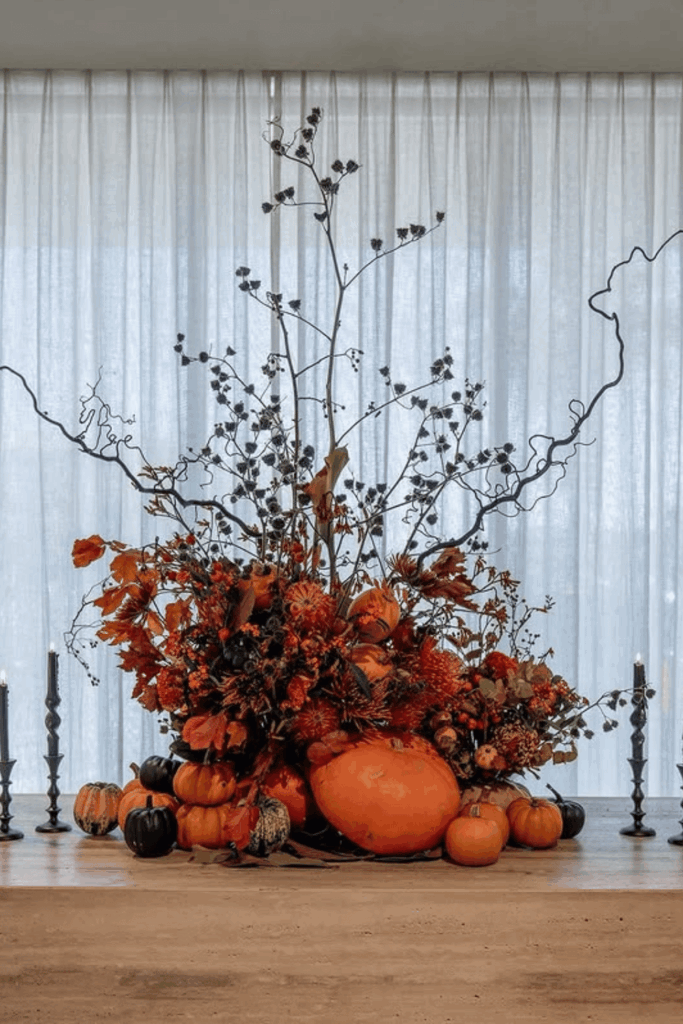 Dramatic Halloween pumpkin and branch centerpiece with flowers