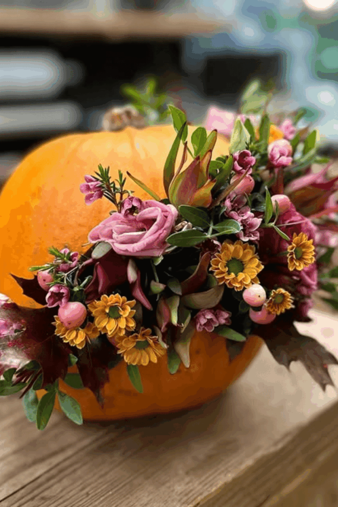 Pumpkin vase with pink and orange flowers for Halloween