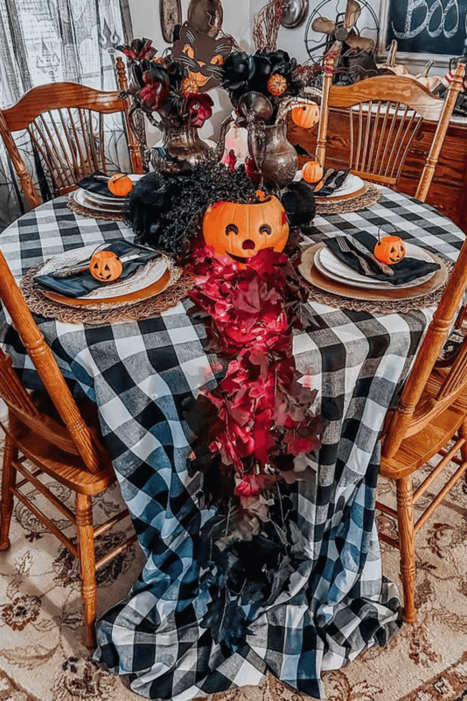 Halloween table with gingham tablecloth, mini pumpkins, and pumpkin centerpiec