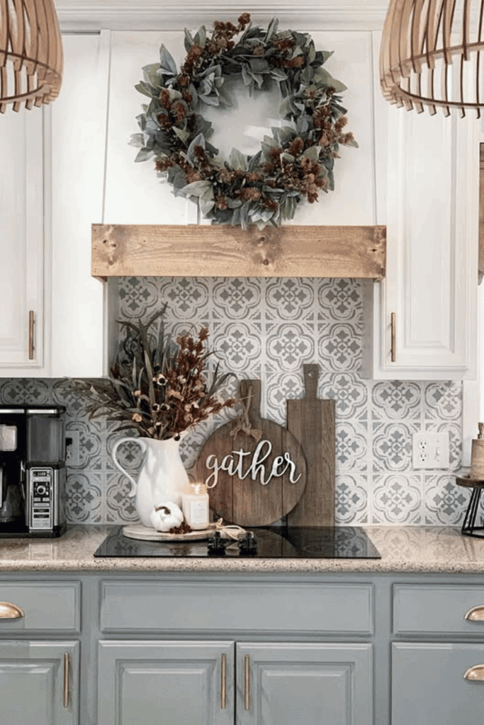 Farmhouse kitchen with patterned backsplash, gather sign, wreath, and fall floral arrangement