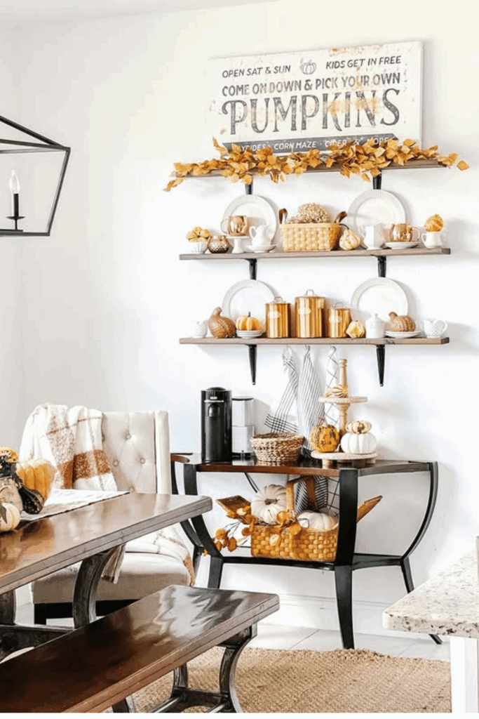 Bright fall kitchen dining area with floating shelves, copper canisters, and pumpkins