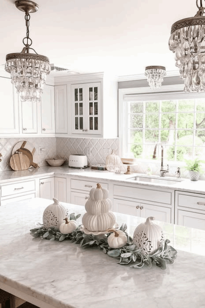 White pumpkins arranged on a kitchen island countertop as a fall centerpiece