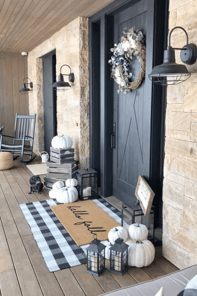 Modern farmhouse porch with white pumpkins, black lanterns, and layered rugs