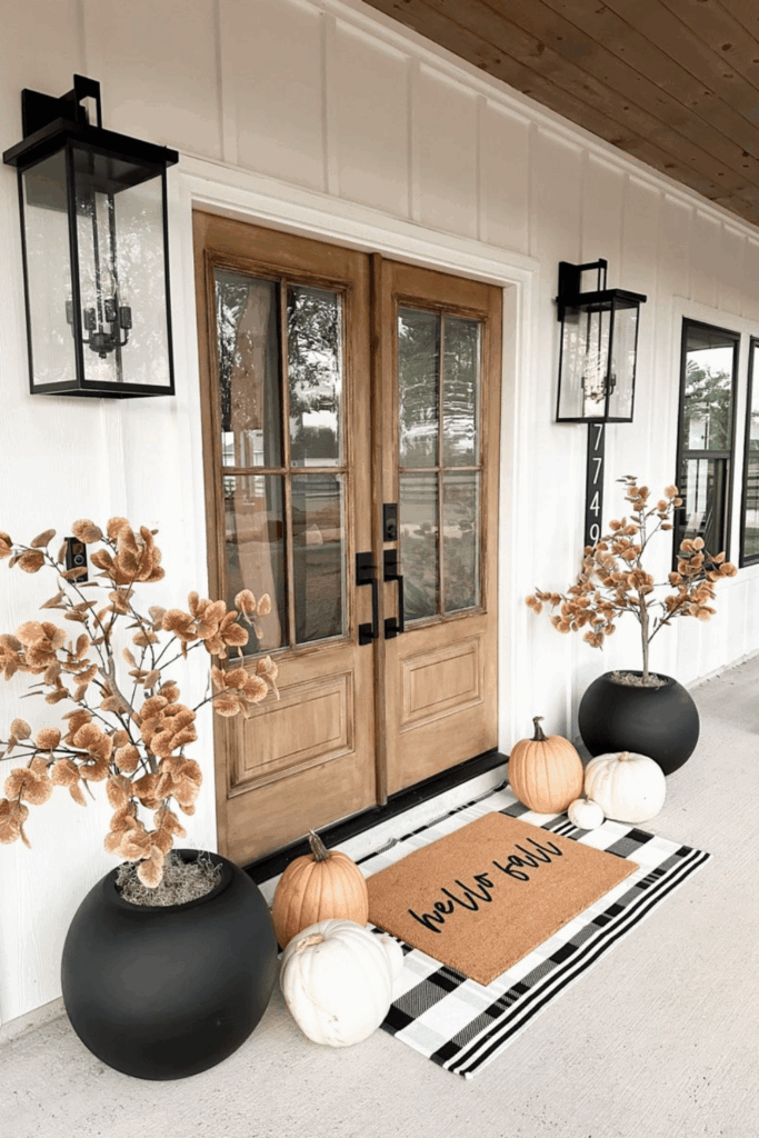 Neutral fall porch decor with white and peach pumpkins and plaid doormat