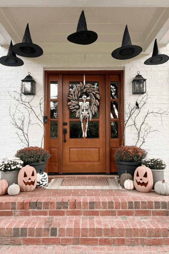 Halloween front porch with skeleton decor, jack-o’-lanterns, and seasonal wreath