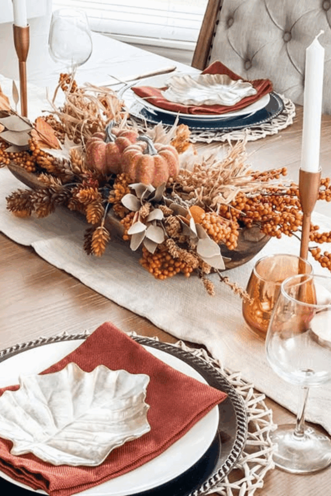 Fall table decor with rust-orange napkins and woven chargers