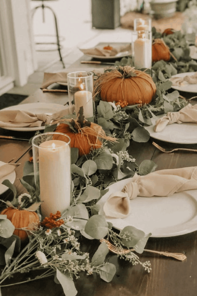 Eucalyptus garland with muted orange pumpkins on fall table