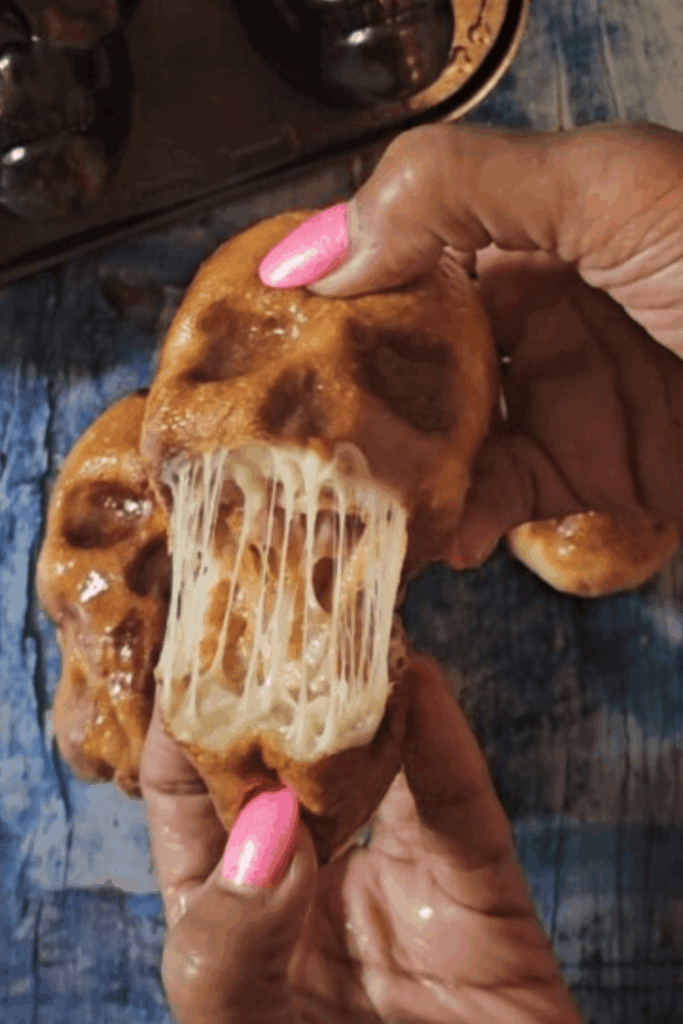 Stuffed bread skulls baked with melted cheese – spooky bone shapes appetizer