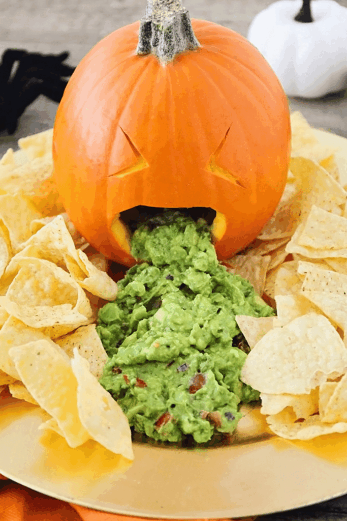 Carved pumpkin vomiting guacamole – unforgettable Halloween party appetizer