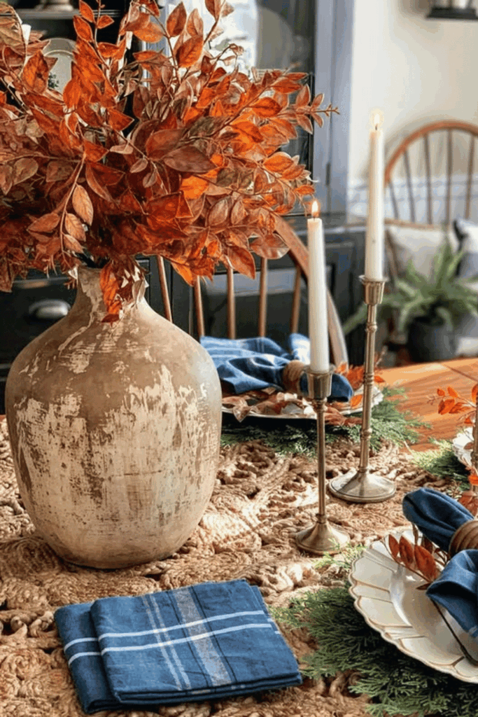 Dining table centerpiece with deep autumn foliage and blue accents