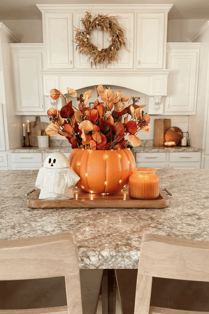 Pumpkin vase centerpiece with fall stems and candles
