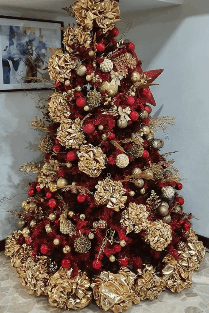 Red and gold Christmas tree decorated with large gold flowers and red ornaments