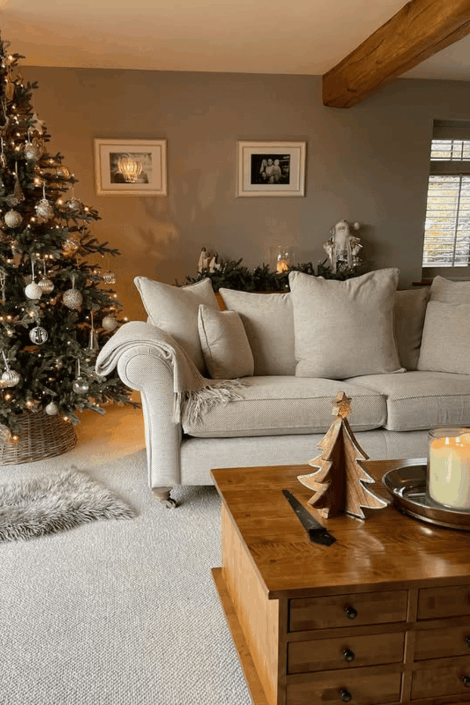 Neutral living room with gold ornaments and a softly lit Christmas tree