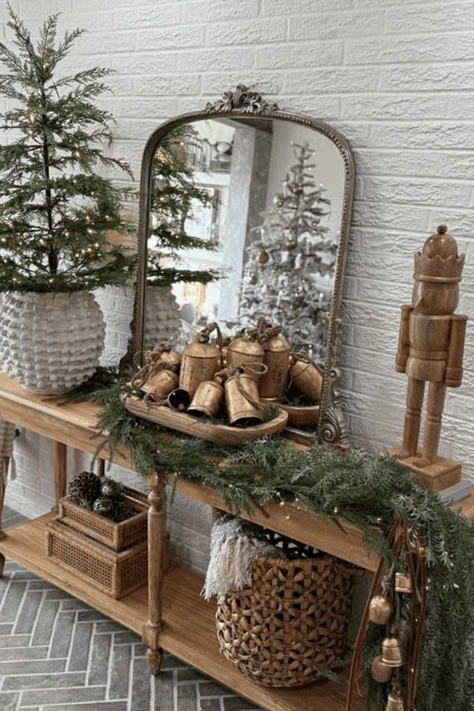 Console table with fresh garland, vintage bells, and Christmas greenery