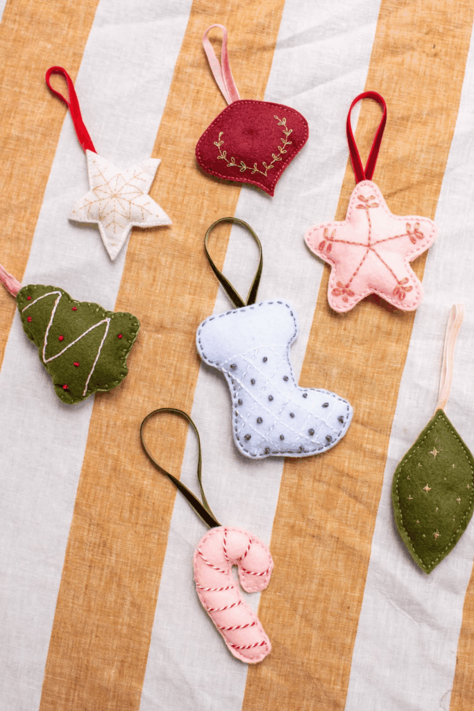 Handmade felt Christmas ornaments in star, tree, stocking, and candy cane shapes