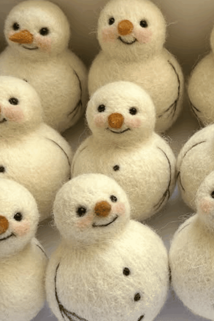 Small needle-felted snowmen with embroidered faces