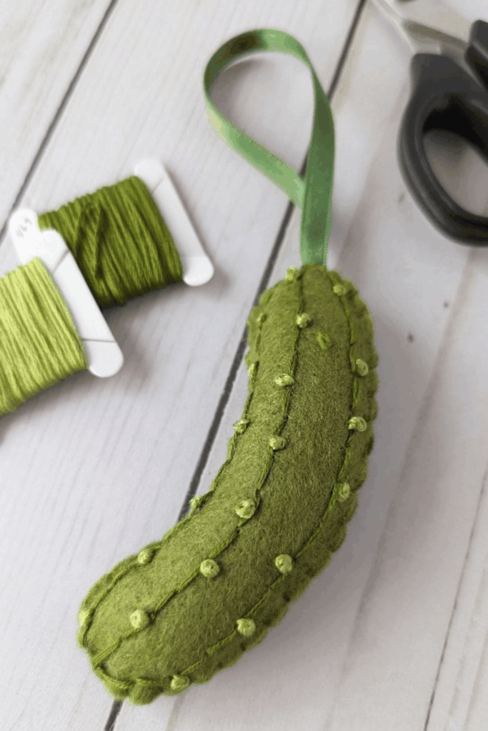 Green felt pickle ornament with knotted texture and ribbon hanger