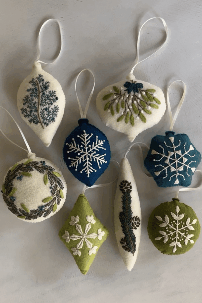 Blue, green, and white embroidered felt Christmas ornaments with winter designs