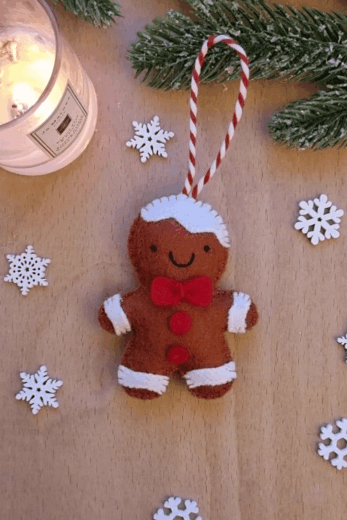 Cute felt gingerbread man ornament with red bow and white icing stitches