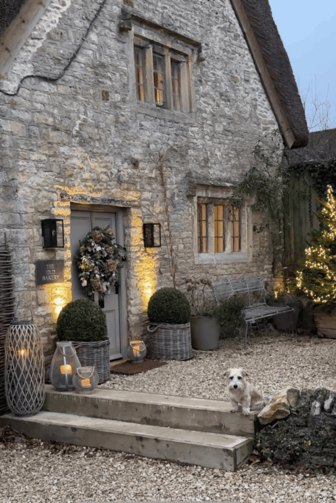 Stone cottage entryway with wreath and warm light Christmas decor