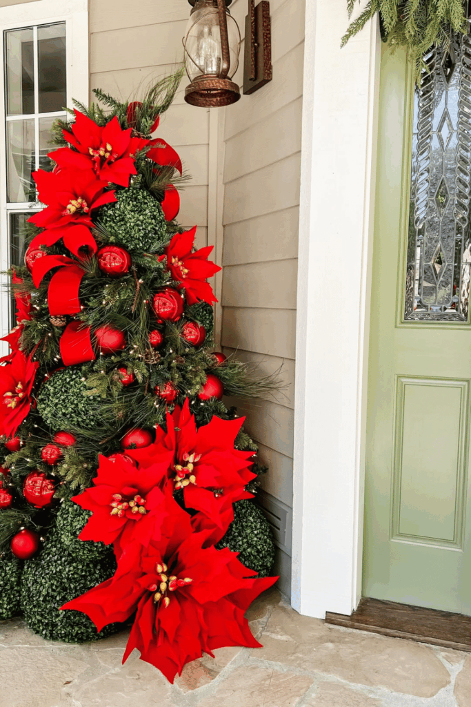 Outdoor topiary decorated with oversized red poinsettias