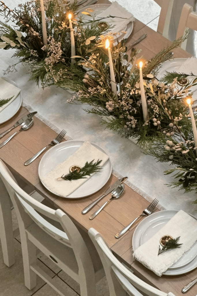 Neutral greenery and candle centerpiece for elegant holiday table setting