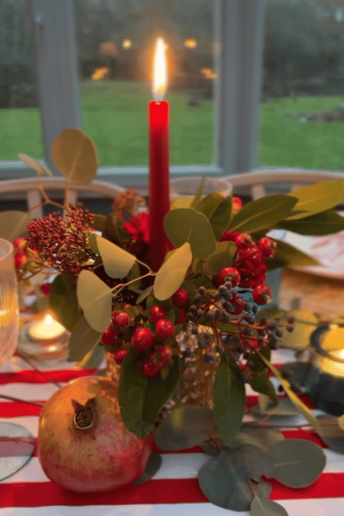 Red berry floral centerpiece with glass vases and candlelight