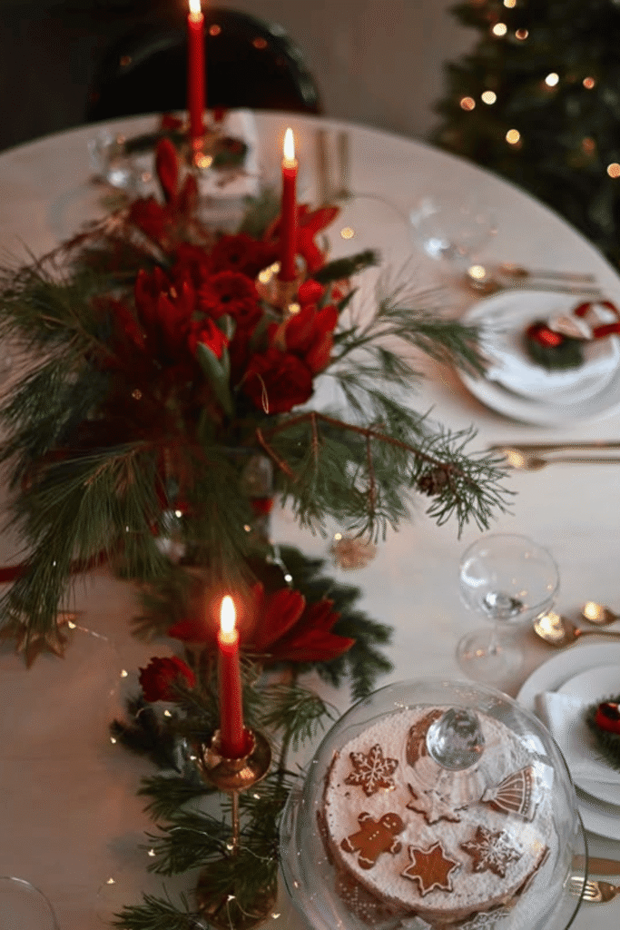 Festive floral centerpiece with red flowers and candles for Christmas dinner table