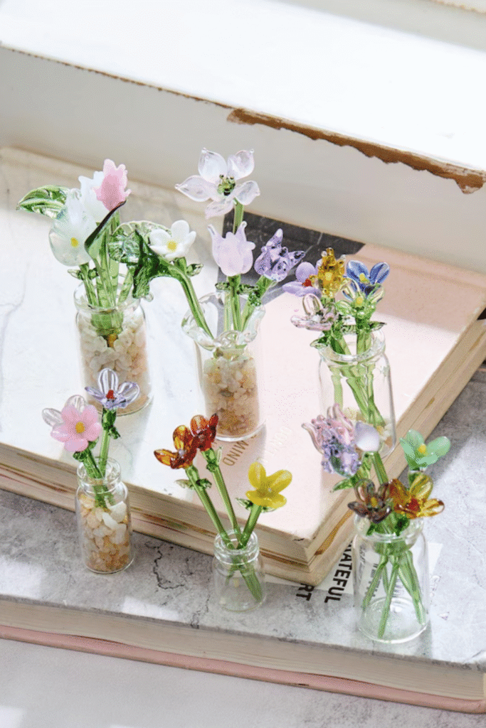 Mini faux flower arrangements in small glass bottles