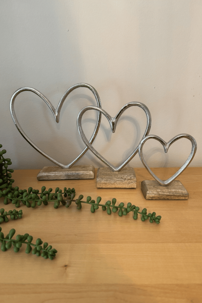 Set of sculptural metal hearts on wooden bases