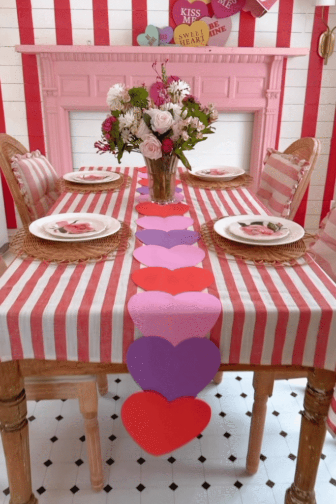 Valentine’s dining table with paper heart table runner and striped tablecloth