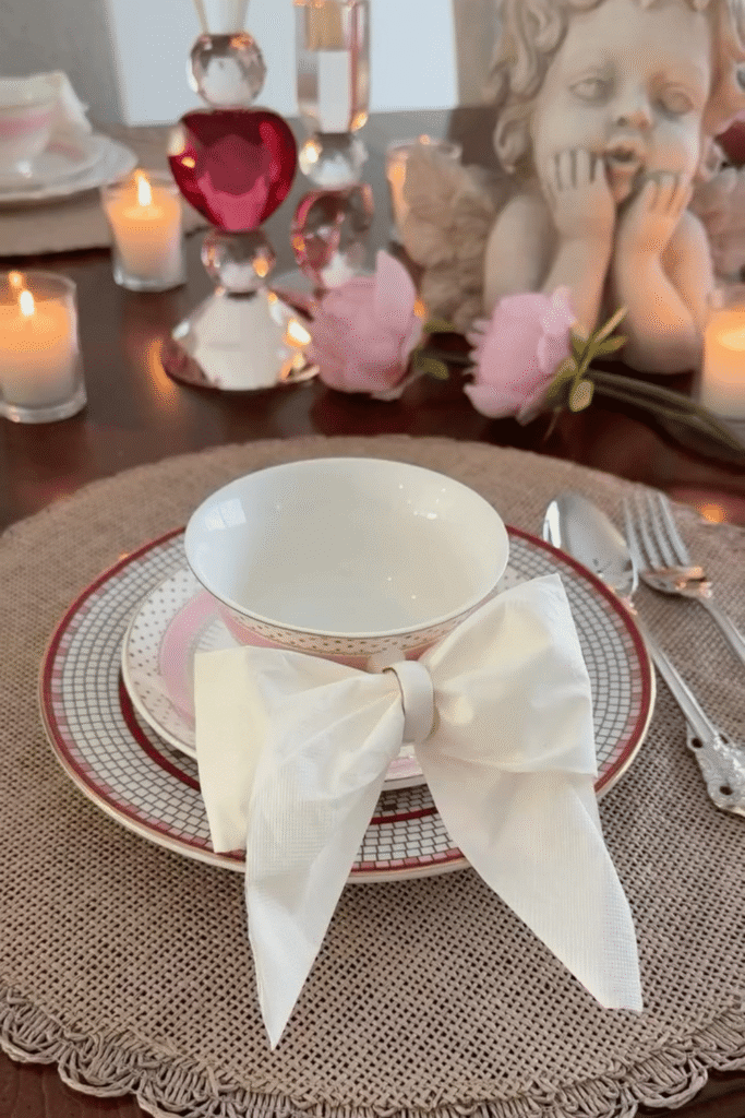 Romantic Valentine’s place setting with bow-tied napkin and candlelit table