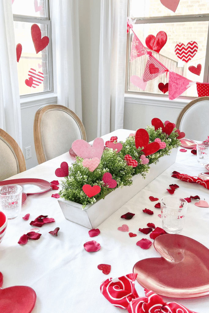 Valentine’s table centerpiece with greenery and red paper hearts