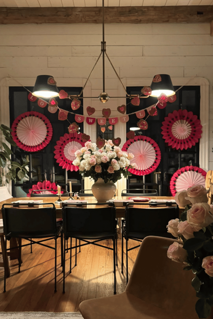 Festive Valentine’s dining room with heart garlands, paper fans, and floral centerpiece